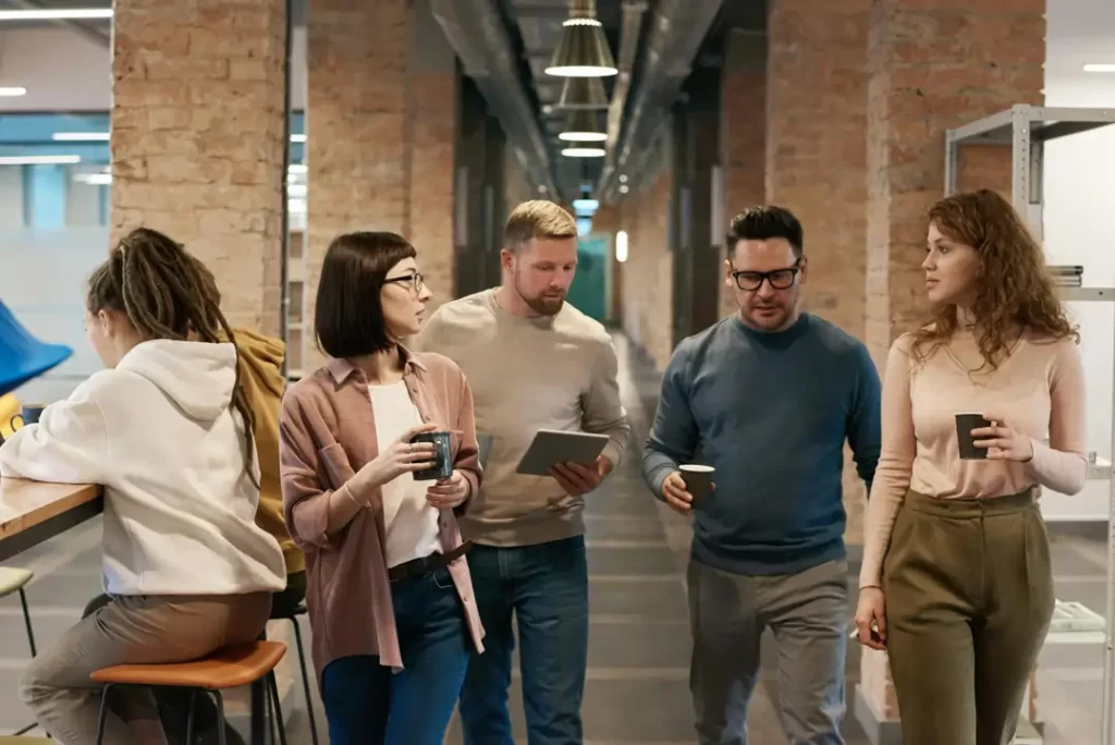 Personale discute su come affrontare una sfida durante la pausa caffè | 4Humans