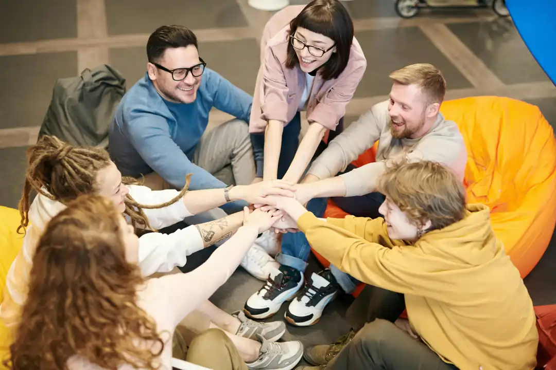 Team unito, seduto in cerchio, che si da la carica in sala relax | 4Humans
