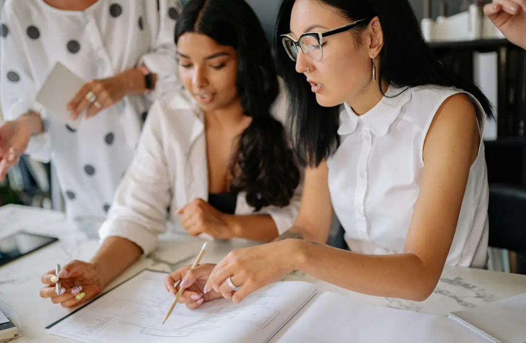 Collaboratrici donne, vestite di bianco, collaborano fra di loro con il sorriso | 4Humans
