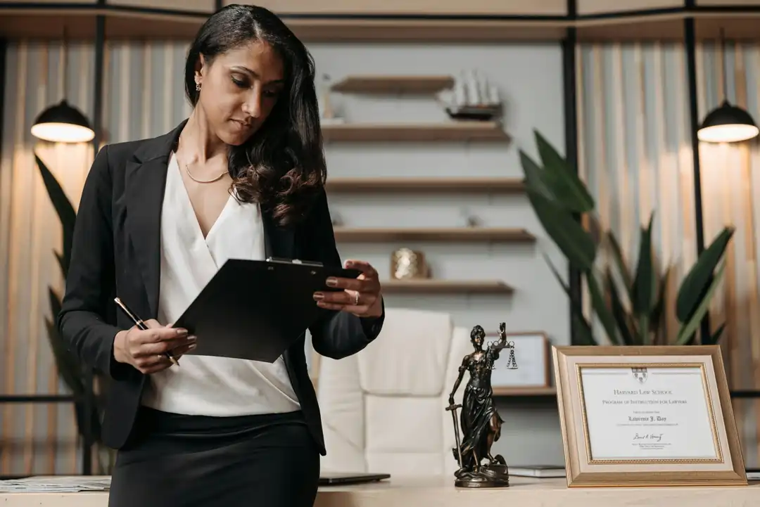 Donna con il suo certificato di laurea incorniciato sulla scrivania, esempio di hard skills | 4Humans